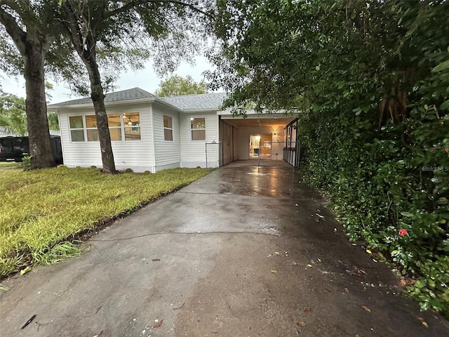 view of front of property with a front yard, driveway, and an attached carport