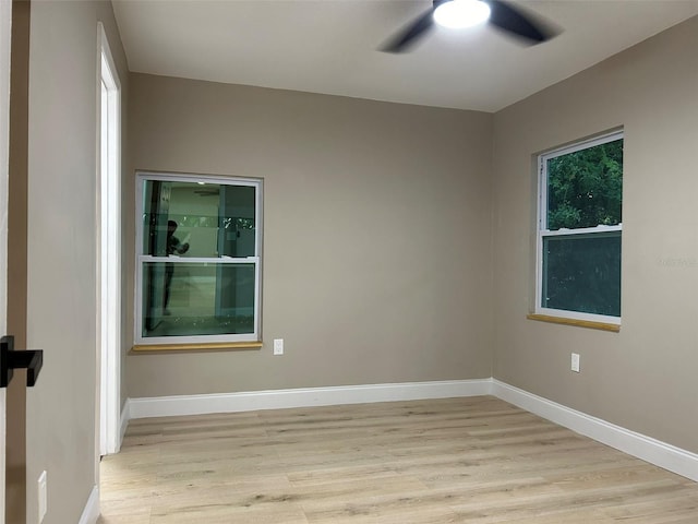 empty room with ceiling fan, light wood-style flooring, and baseboards