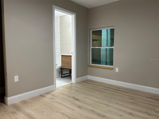 spare room featuring light wood-style flooring and baseboards