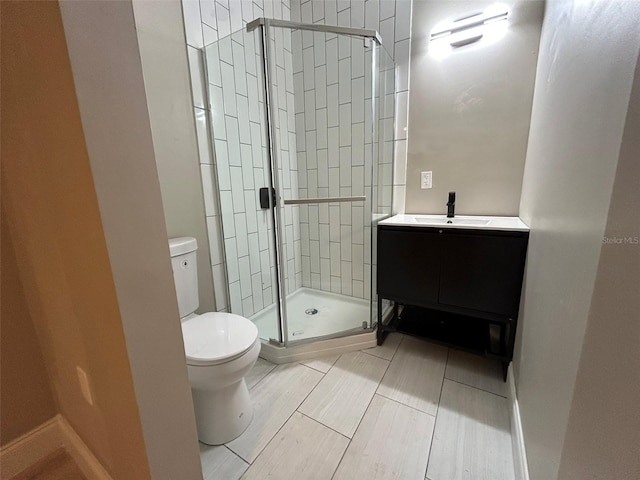 bathroom featuring a stall shower, vanity, and toilet