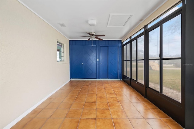 unfurnished sunroom with a ceiling fan and visible vents