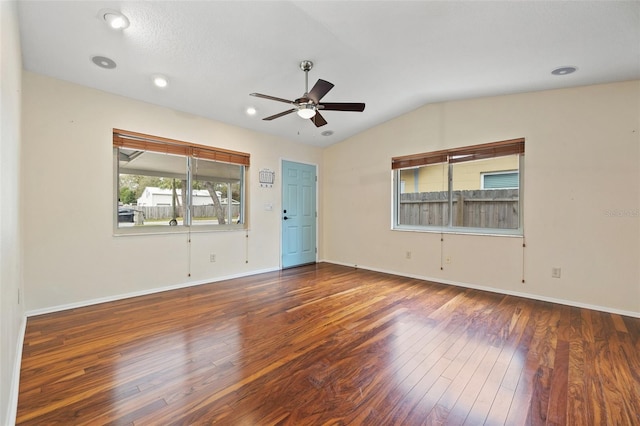 unfurnished room with a ceiling fan, lofted ceiling, dark wood-style flooring, and baseboards