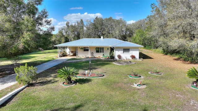 view of front of house with an attached carport, metal roof, driveway, and a front lawn