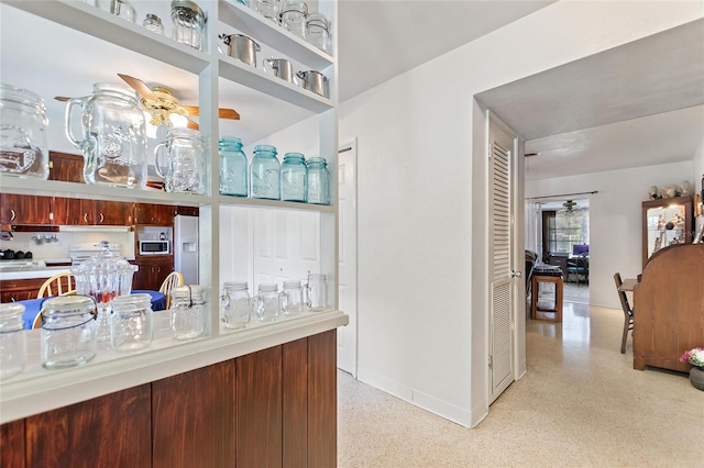 4310 Indian Lake Dr, Indian Lake Estates, FL 33855 - kitchen featuring ceiling fan, light speckled floor, stainless steel microwave, and fridge with ice dispenser