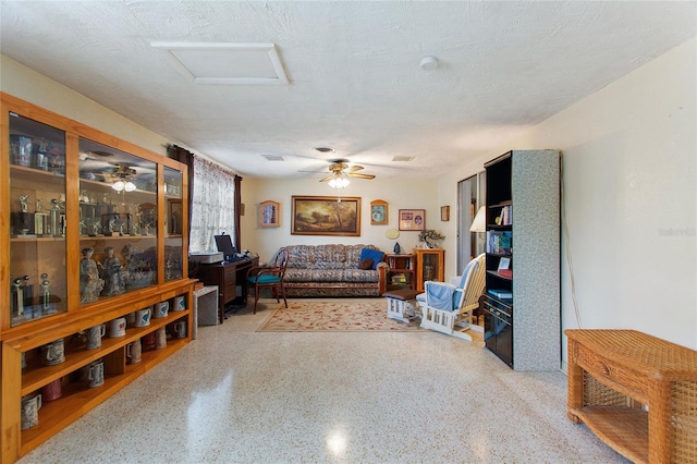 4310 Indian Lake Dr, Indian Lake Estates, FL 33855 - living area with a textured ceiling, ceiling fan, speckled floor, and attic access