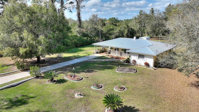 4310 Indian Lake Dr, Indian Lake Estates, FL 33855 - view of front of home with a porch, a front yard, metal roof, a wooded view, and driveway