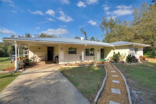 4310 Indian Lake Dr, Indian Lake Estates, FL 33855 - view of front of property with concrete driveway, metal roof, a front yard, a carport, and stucco siding