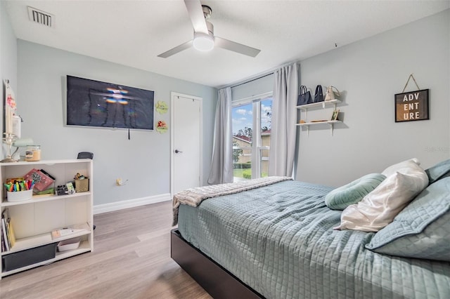 bedroom featuring ceiling fan, wood finished floors, visible vents, and baseboards