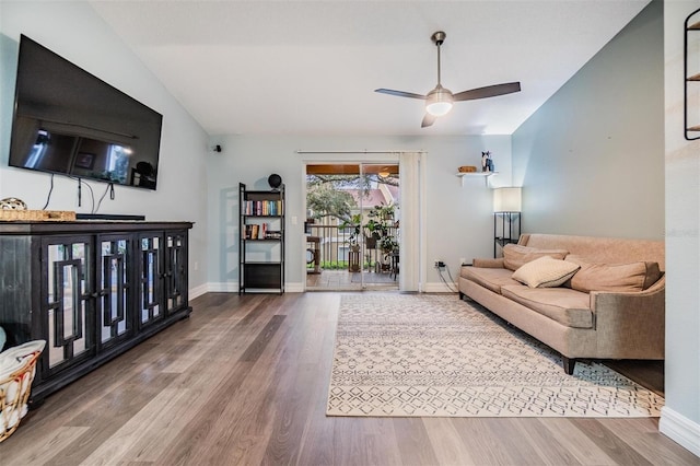 living room with ceiling fan, baseboards, vaulted ceiling, and wood finished floors