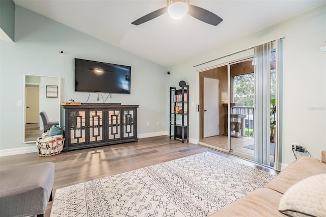 living room featuring vaulted ceiling, ceiling fan, wood finished floors, and baseboards