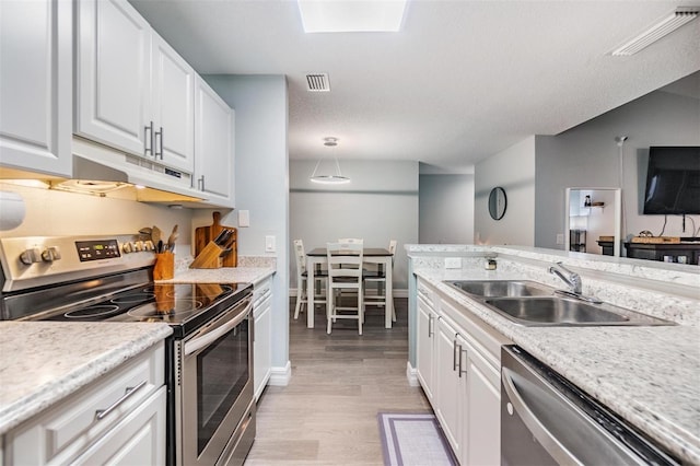 kitchen featuring appliances with stainless steel finishes, visible vents, and white cabinets