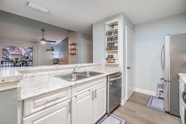 kitchen with visible vents, light wood-style flooring, stainless steel appliances, white cabinetry, and a sink