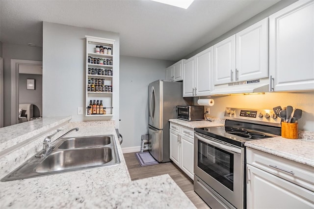 9481 Highland Oak Dr Unit 706, Tampa, FL 33647 - kitchen with appliances with stainless steel finishes, under cabinet range hood, a sink, light wood finished floors, and white cabinets