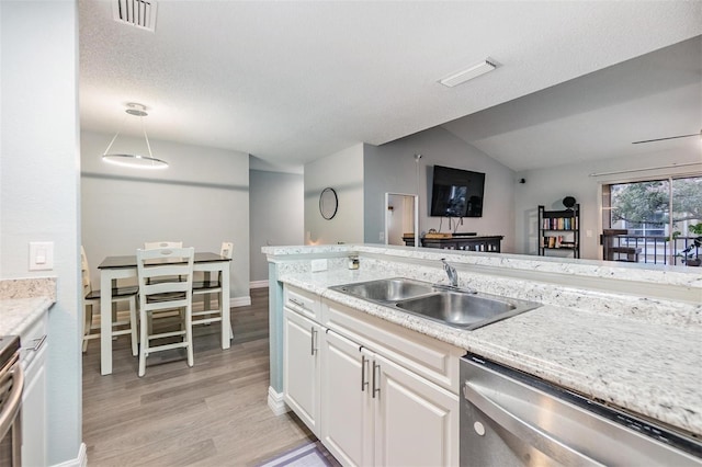 9481 Highland Oak Dr Unit 706, Tampa, FL 33647 - kitchen with dishwasher, a sink, light wood-style flooring, white cabinets, and lofted ceiling