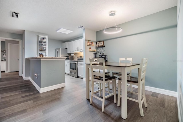 9481 Highland Oak Dr Unit 706, Tampa, FL 33647 - dining area with wood finished floors, baseboards, and a textured ceiling