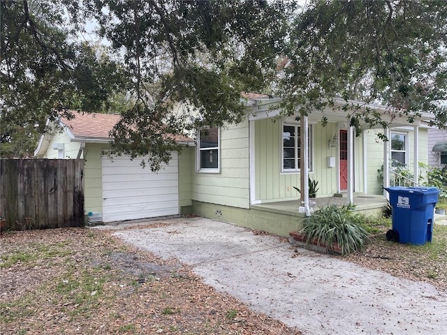 view of front facade with an attached garage, a shingled roof, fence, concrete driveway, and board and batten siding