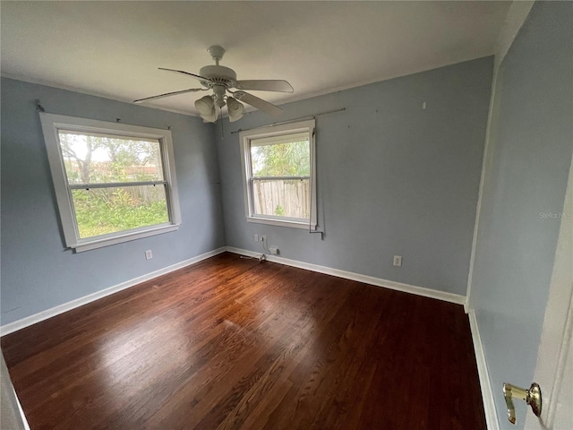 empty room with ceiling fan, baseboards, and dark wood finished floors