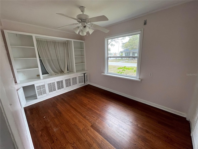 empty room with dark wood-type flooring, baseboards, ornamental molding, and radiator heating unit