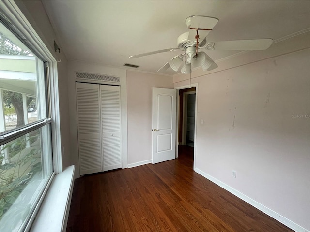 unfurnished bedroom featuring baseboards, visible vents, ceiling fan, dark wood-style flooring, and a closet