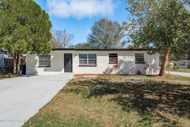 single story home with a front yard, brick siding, and fence