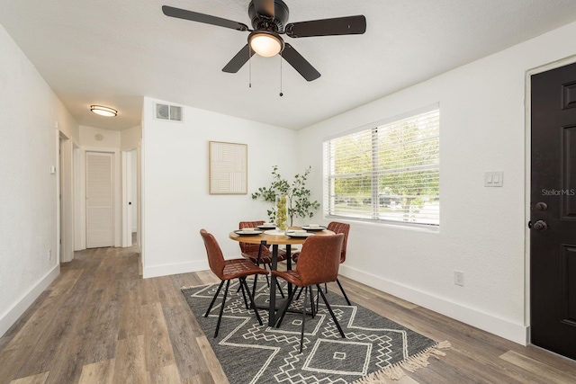 dining space with visible vents, baseboards, and wood finished floors