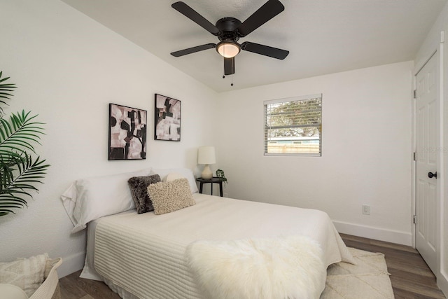 bedroom featuring ceiling fan, a closet, wood finished floors, and baseboards