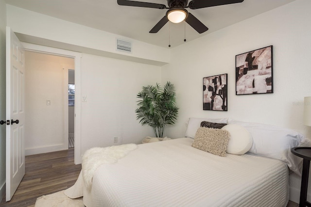 bedroom with baseboards, ceiling fan, visible vents, and wood finished floors