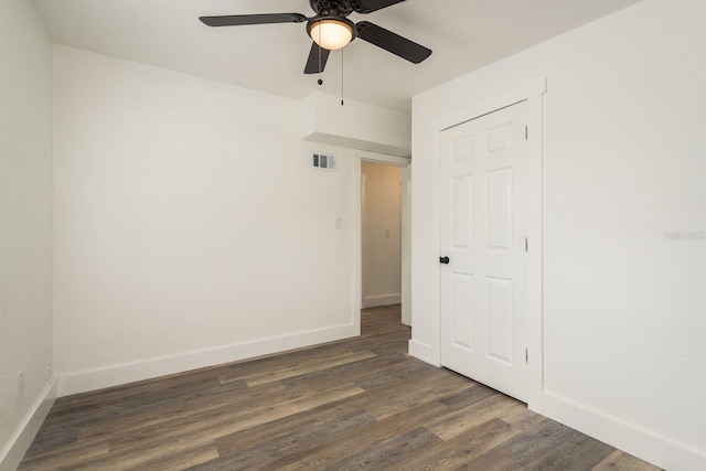 spare room featuring a ceiling fan, baseboards, visible vents, and wood finished floors