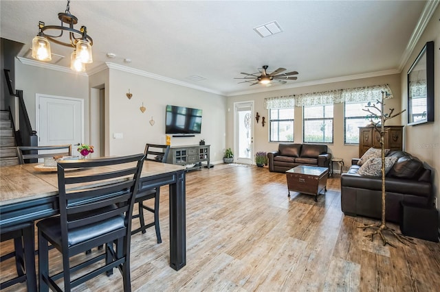 living room with ornamental molding, wood finished floors, and visible vents