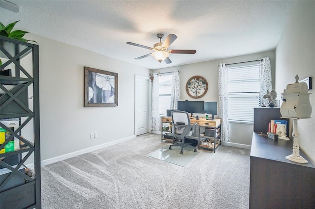 home office with light colored carpet, ceiling fan, a textured ceiling, and baseboards