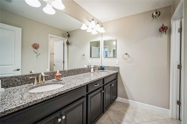 full bathroom featuring tile patterned flooring, a sink, baseboards, and double vanity