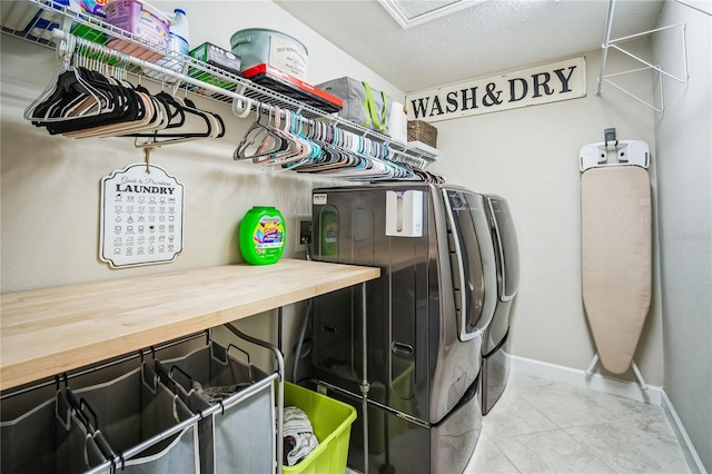 washroom featuring baseboards, laundry area, light tile patterned flooring, and washer and dryer