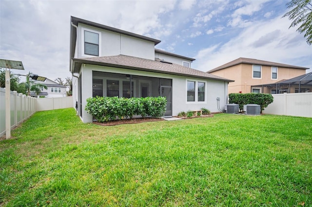 back of house with a yard, stucco siding, a sunroom, cooling unit, and a fenced backyard