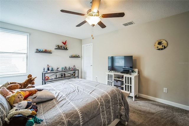 bedroom featuring baseboards, visible vents, a ceiling fan, a textured ceiling, and carpet floors