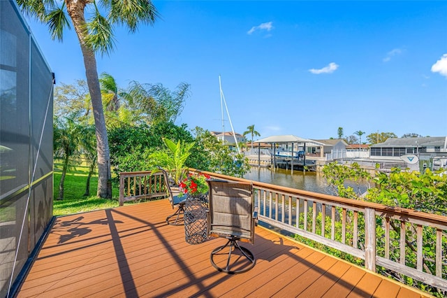 wooden terrace with glass enclosure, a water view, and a residential view