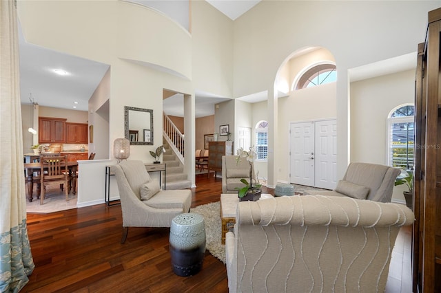 living room featuring dark wood-style floors, a high ceiling, stairway, and baseboards