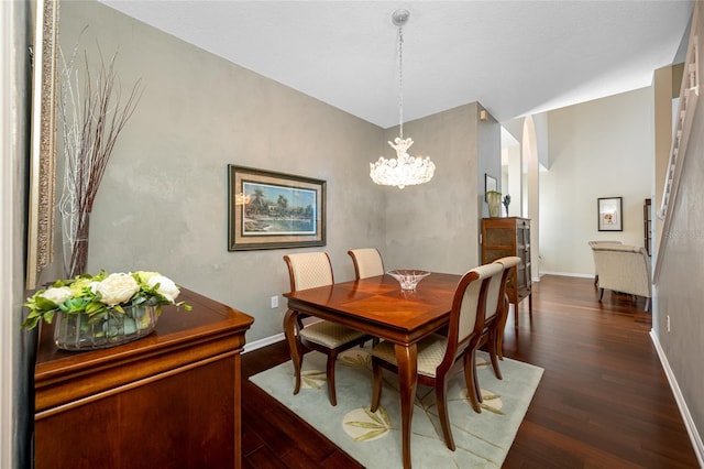 dining area featuring dark wood-style flooring, baseboards, and an inviting chandelier