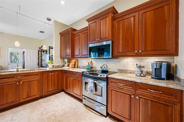 kitchen featuring tasteful backsplash, light stone counters, brown cabinets, stainless steel appliances, and pendant lighting