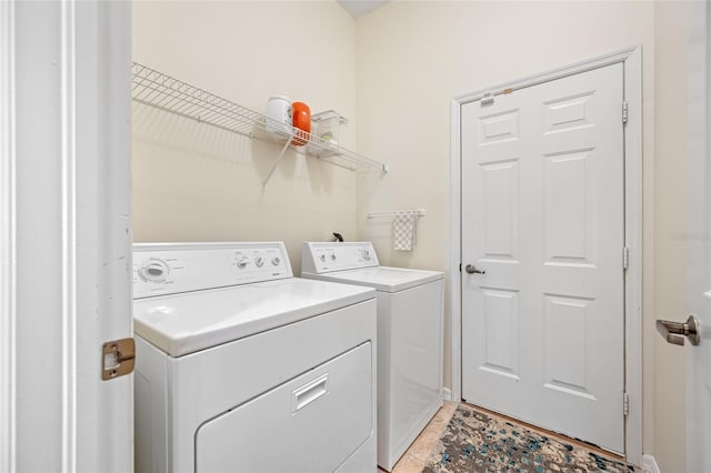 laundry area with laundry area, light tile patterned flooring, and washing machine and clothes dryer