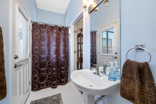 full bathroom featuring curtained shower, a sink, and tile patterned floors