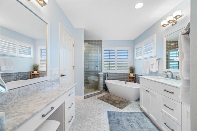 bathroom featuring a stall shower, a freestanding tub, and vanity