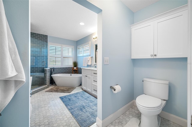 full bathroom with a freestanding bath, toilet, a stall shower, vanity, and baseboards