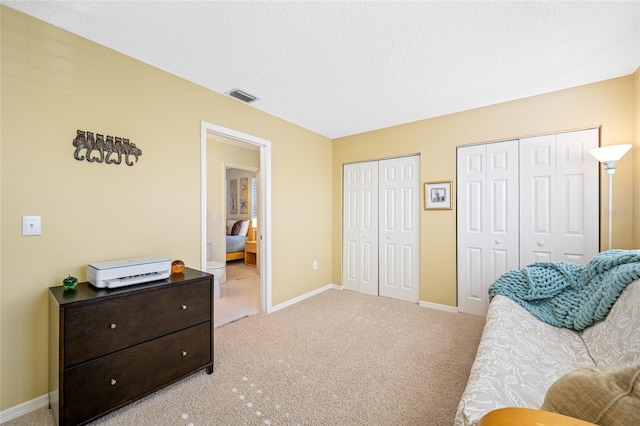 living area featuring light colored carpet, visible vents, a textured ceiling, and baseboards