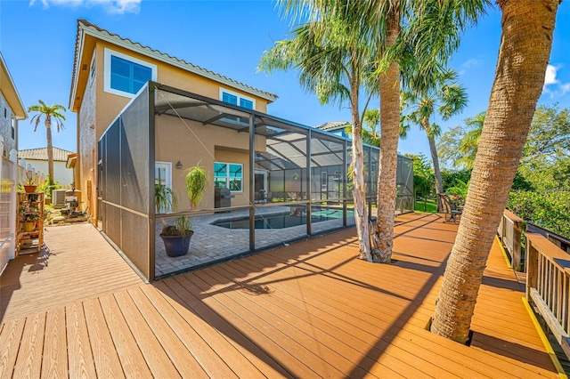 wooden terrace with a lanai and an outdoor pool