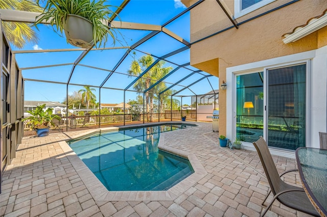 view of pool with a fenced in pool, glass enclosure, and a patio area