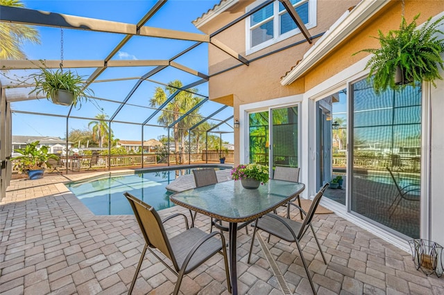 exterior space featuring a fenced in pool, outdoor dining space, and glass enclosure