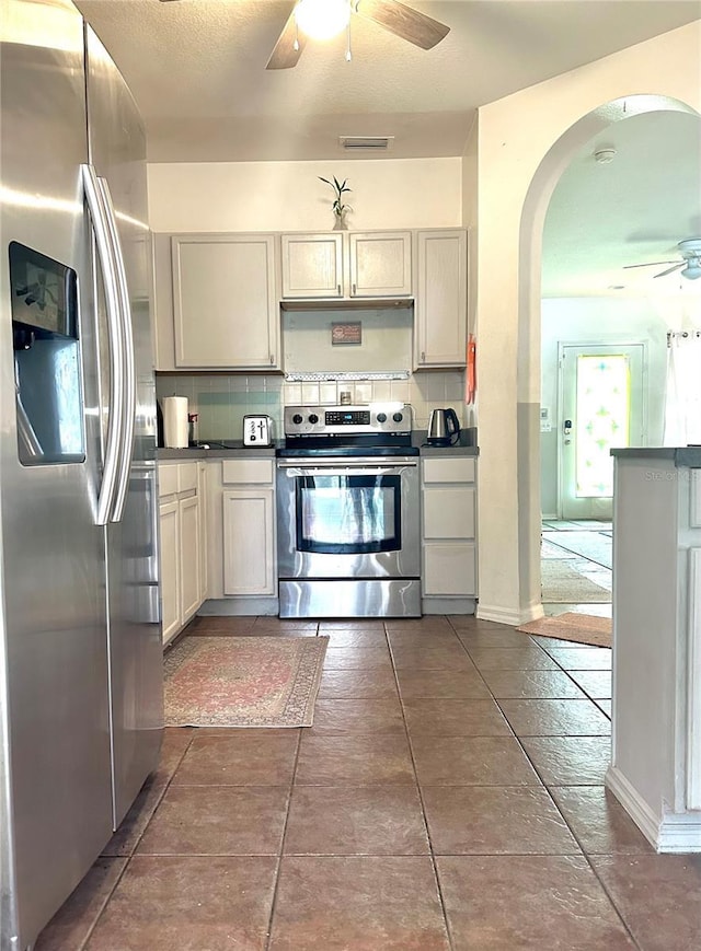 kitchen with stainless steel appliances, dark countertops, and backsplash