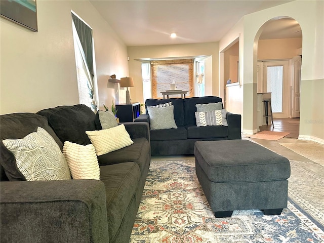 living area featuring baseboards and arched walkways