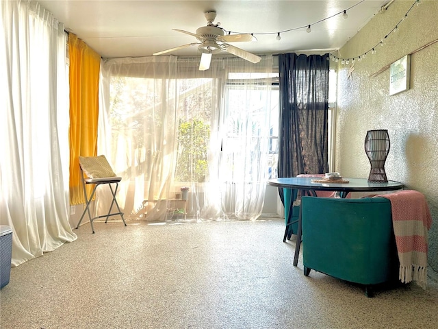 living area featuring ceiling fan, track lighting, and speckled floor