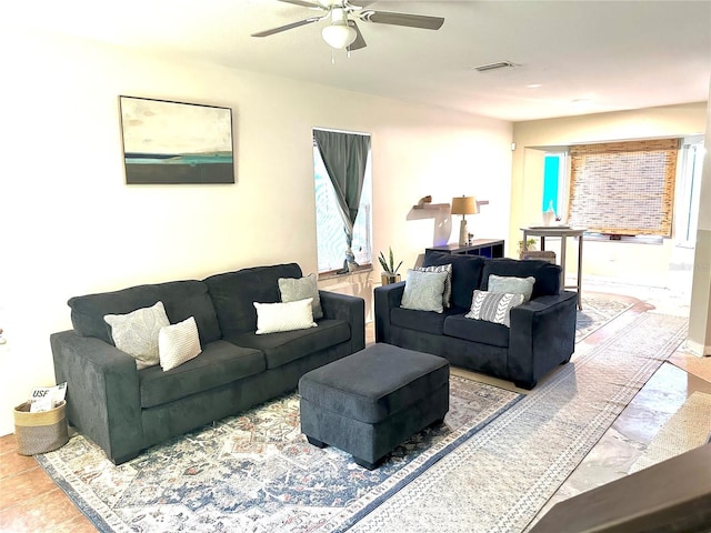 living room with ceiling fan, visible vents, and tile patterned floors